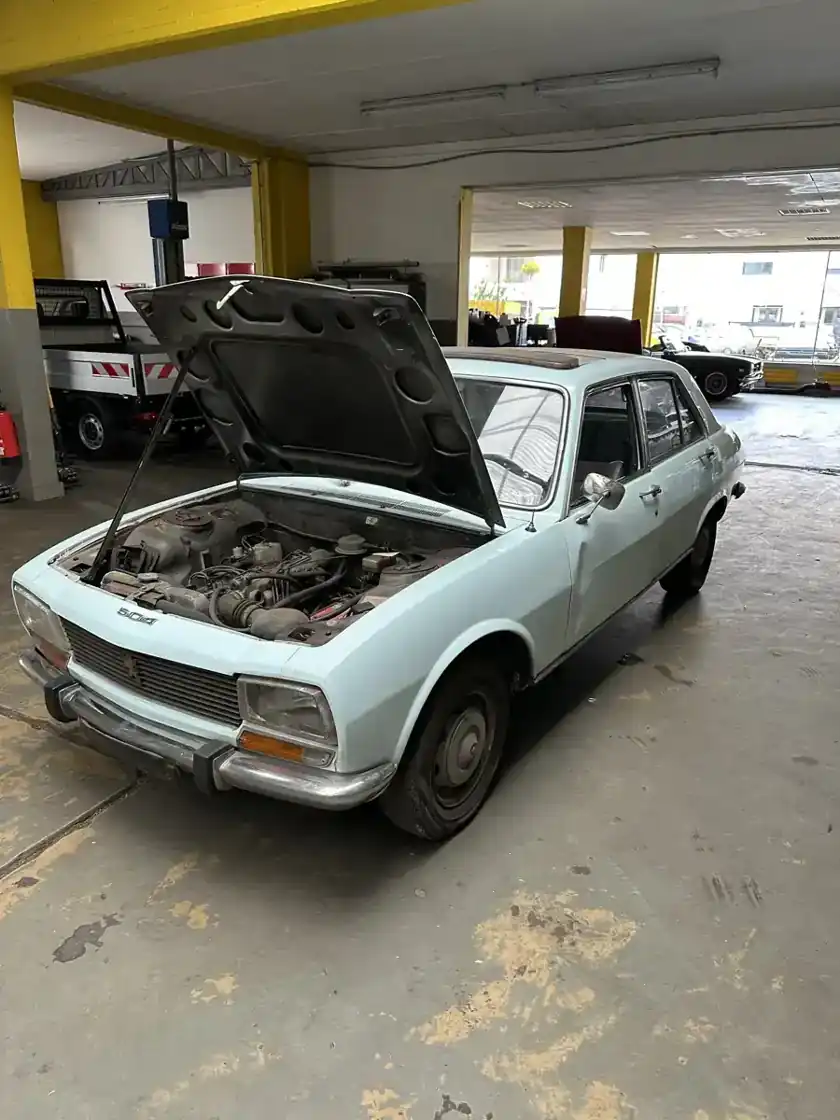 Peugeot 504 mit geöffneter Motorhaube von vorne