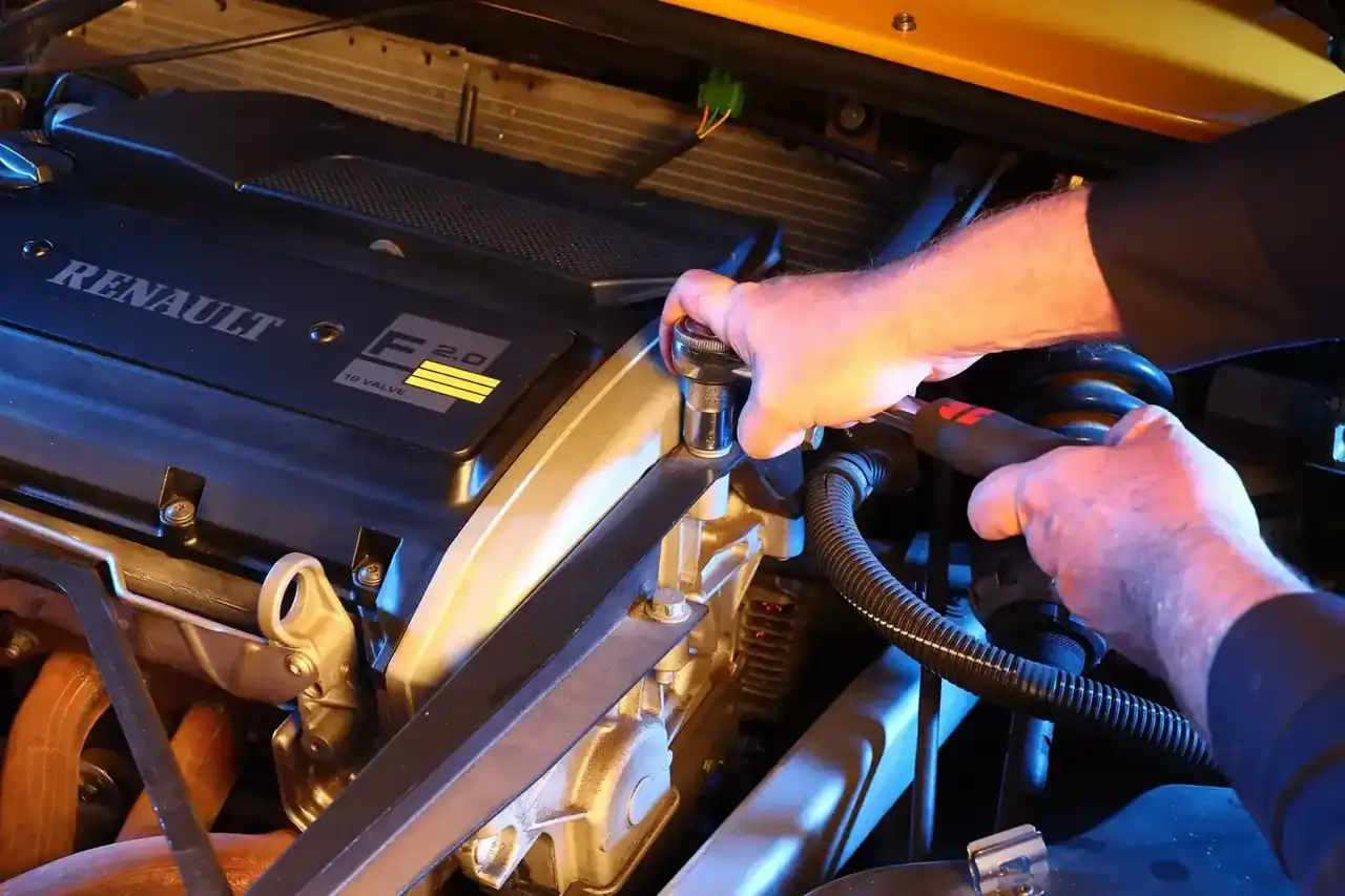 Hände arbeiten im Motorraum eines Renault Sport Spider
